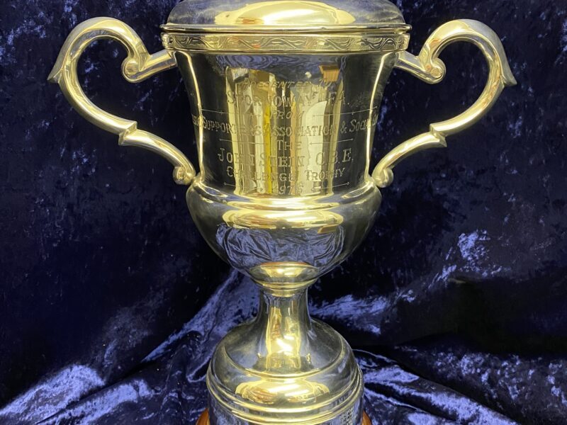 large silver trophy with wooden stand